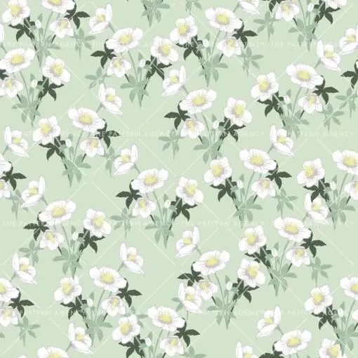 A seamless pattern with white Christmas rose flowers on a green background. The detailed flowers with their soft petals and yellow stamens create an elegant and sophisticated feel